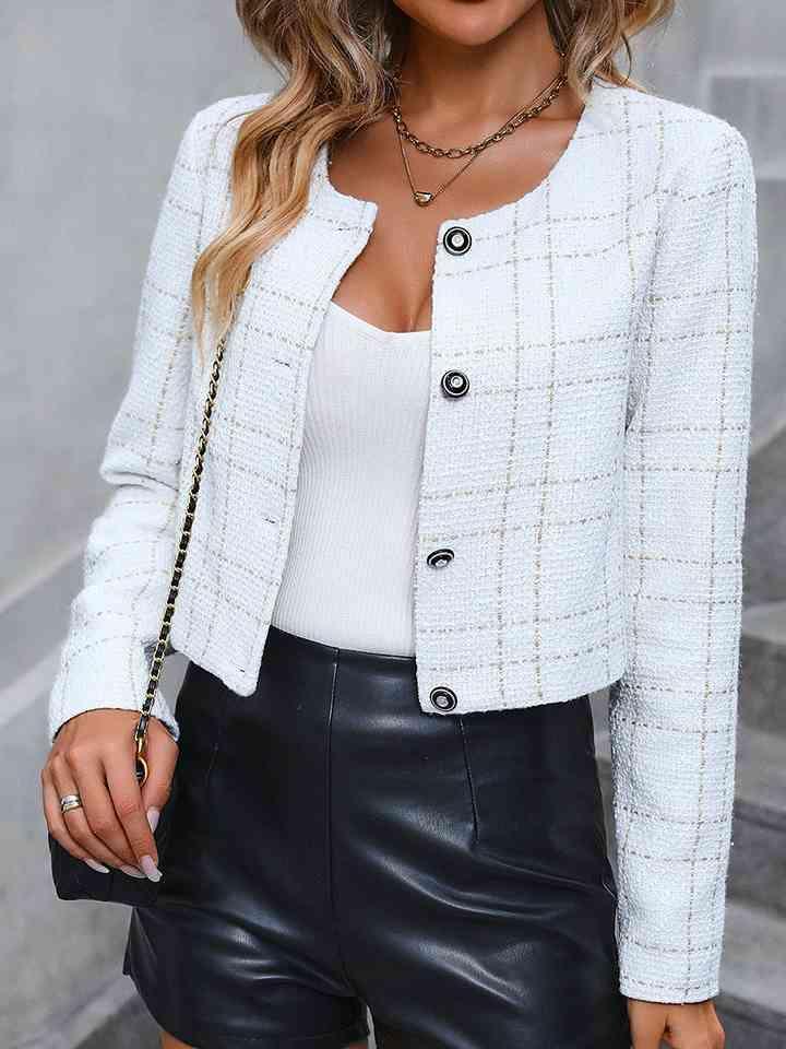 a woman wearing a white jacket and black leather shorts