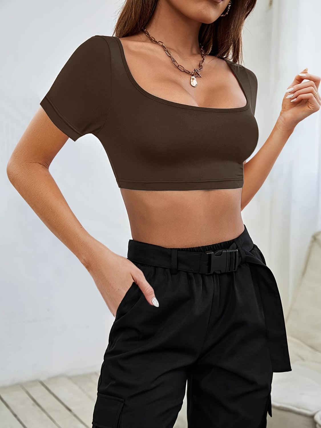 a woman in a crop top poses for a picture