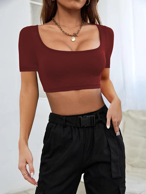 a woman wearing a crop top and black pants