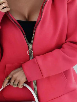 a woman in a red jacket holding a white purse
