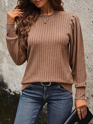 a woman wearing a brown sweater and jeans