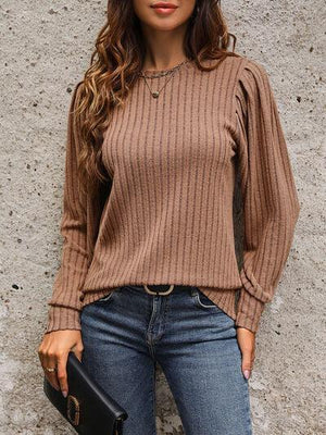 a woman wearing a brown sweater and jeans