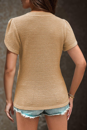 a woman wearing a short sleeved top and shorts