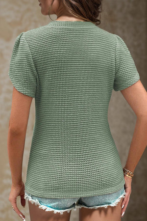 a woman wearing a green shirt and shorts