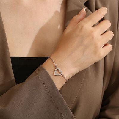 a woman wearing a bracelet with a heart on it