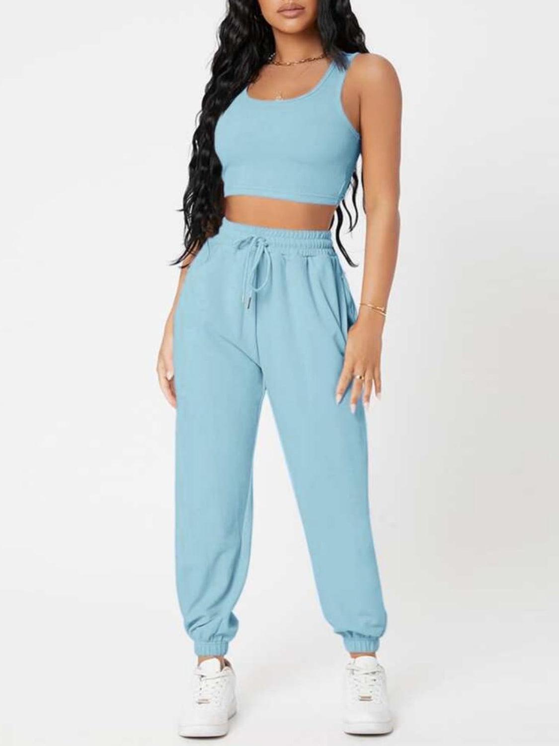 a woman wearing a blue crop top and sweat pants