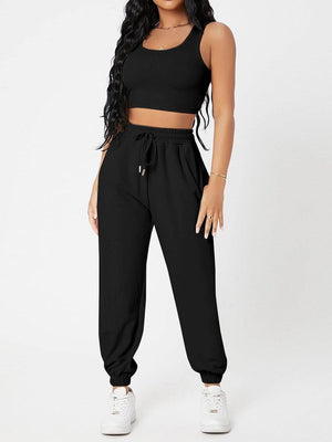 a woman wearing a black crop top and pants