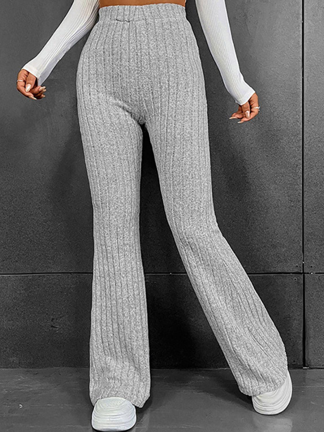 a woman in a white top and grey pants