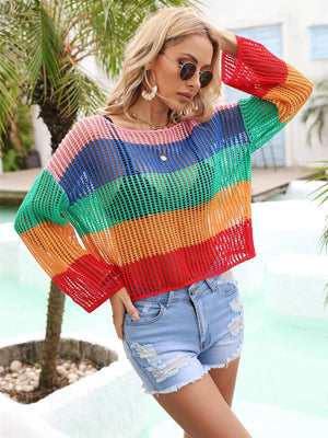 a woman wearing a colorful sweater and denim shorts