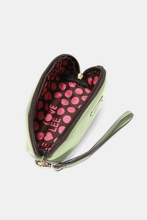 a green and pink heart shaped purse on a white surface