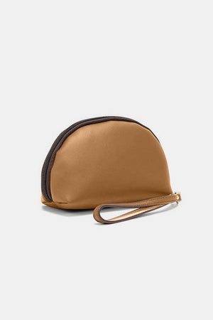 a small tan purse with a black strap
