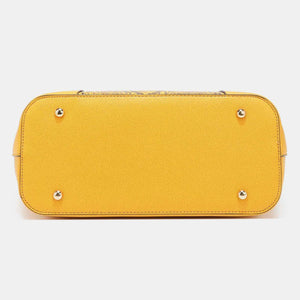 a yellow purse with rivets on the front