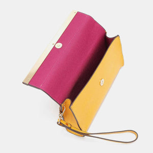 a yellow and pink purse sitting on top of a white table