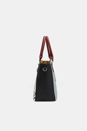 a black and white handbag with a red handle