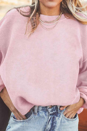 a woman wearing a pink sweater and jeans