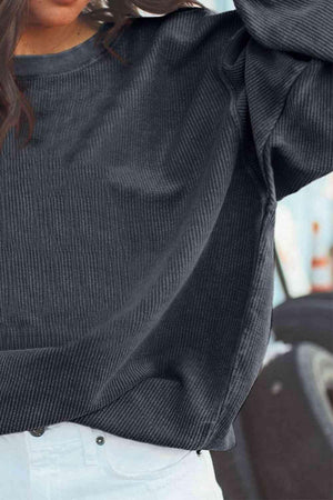 a woman wearing a black sweater and white pants