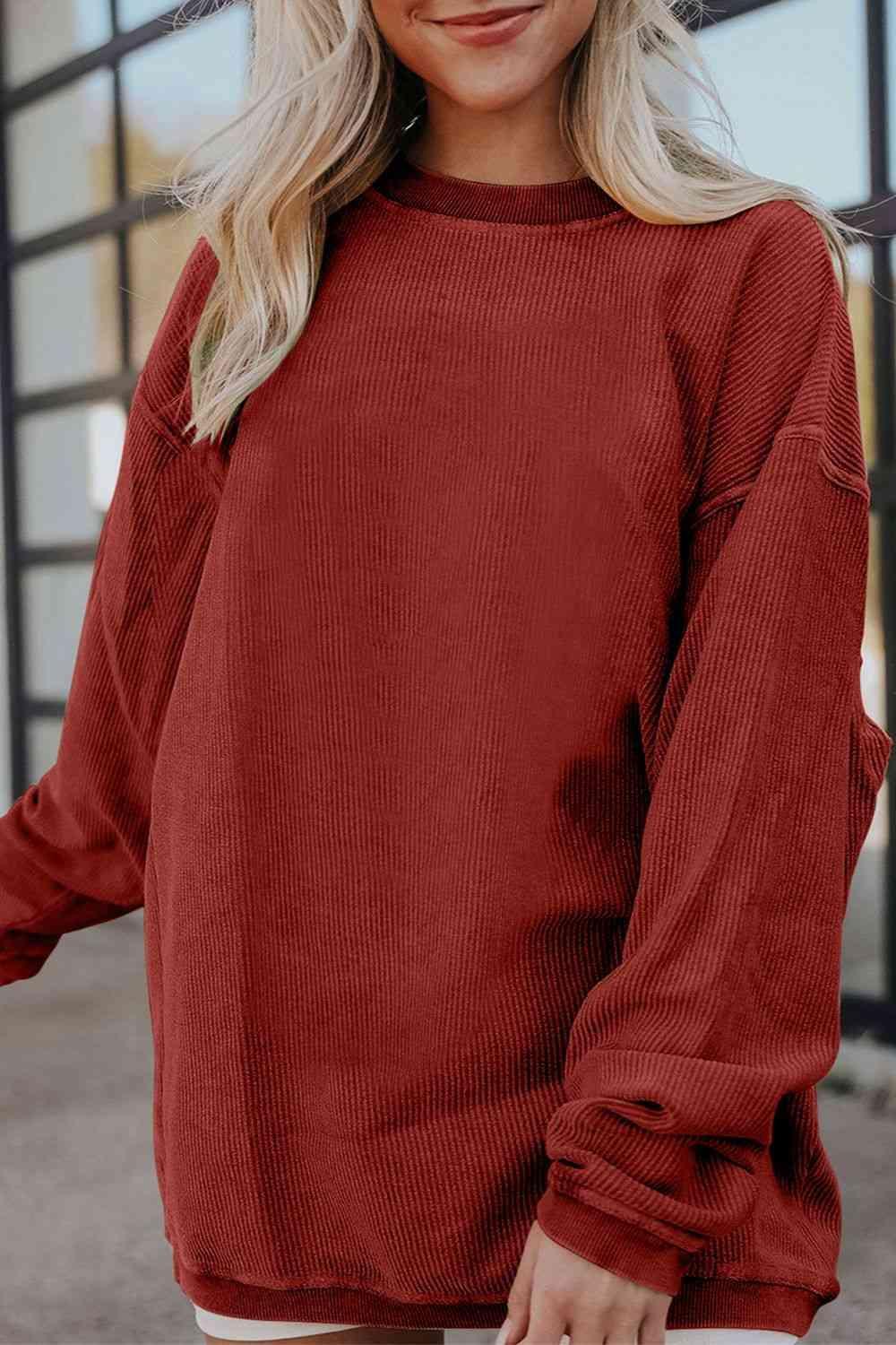 a woman wearing a red sweater and white shorts
