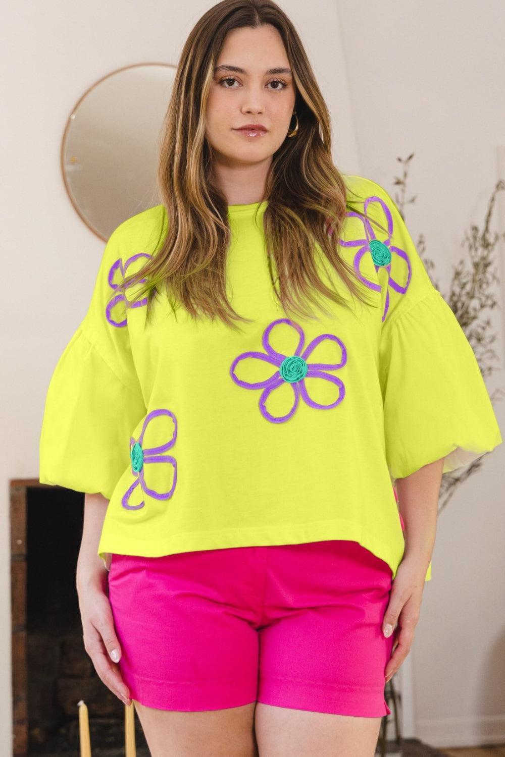 a woman in a yellow top and pink shorts