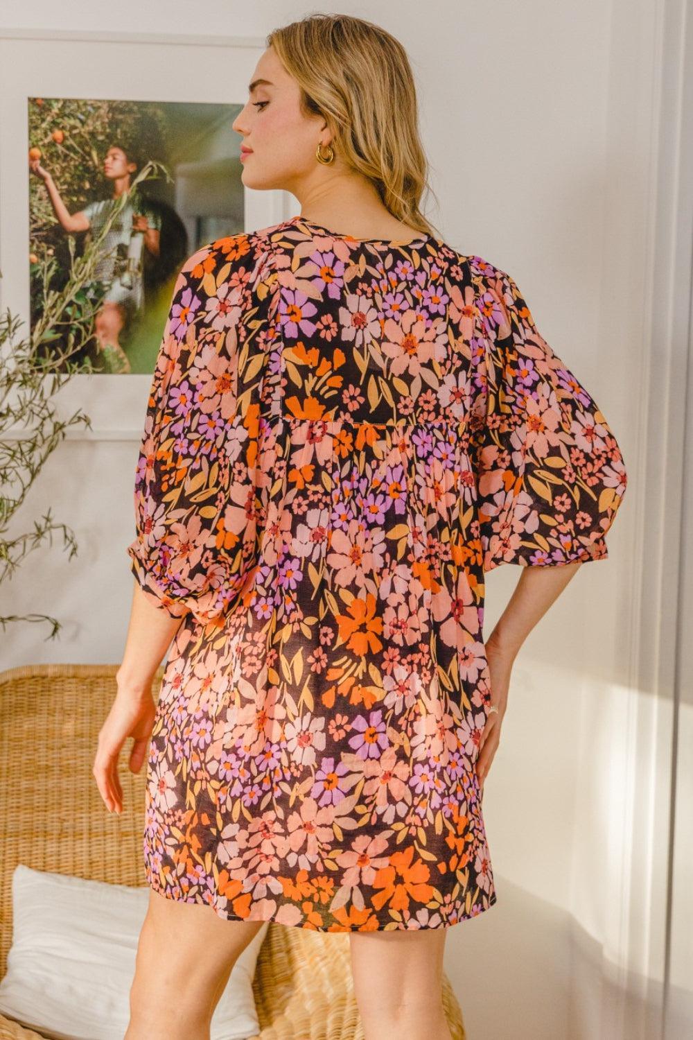 a woman standing in a living room wearing a dress