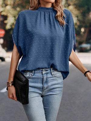 a woman wearing a blue blouse and jeans