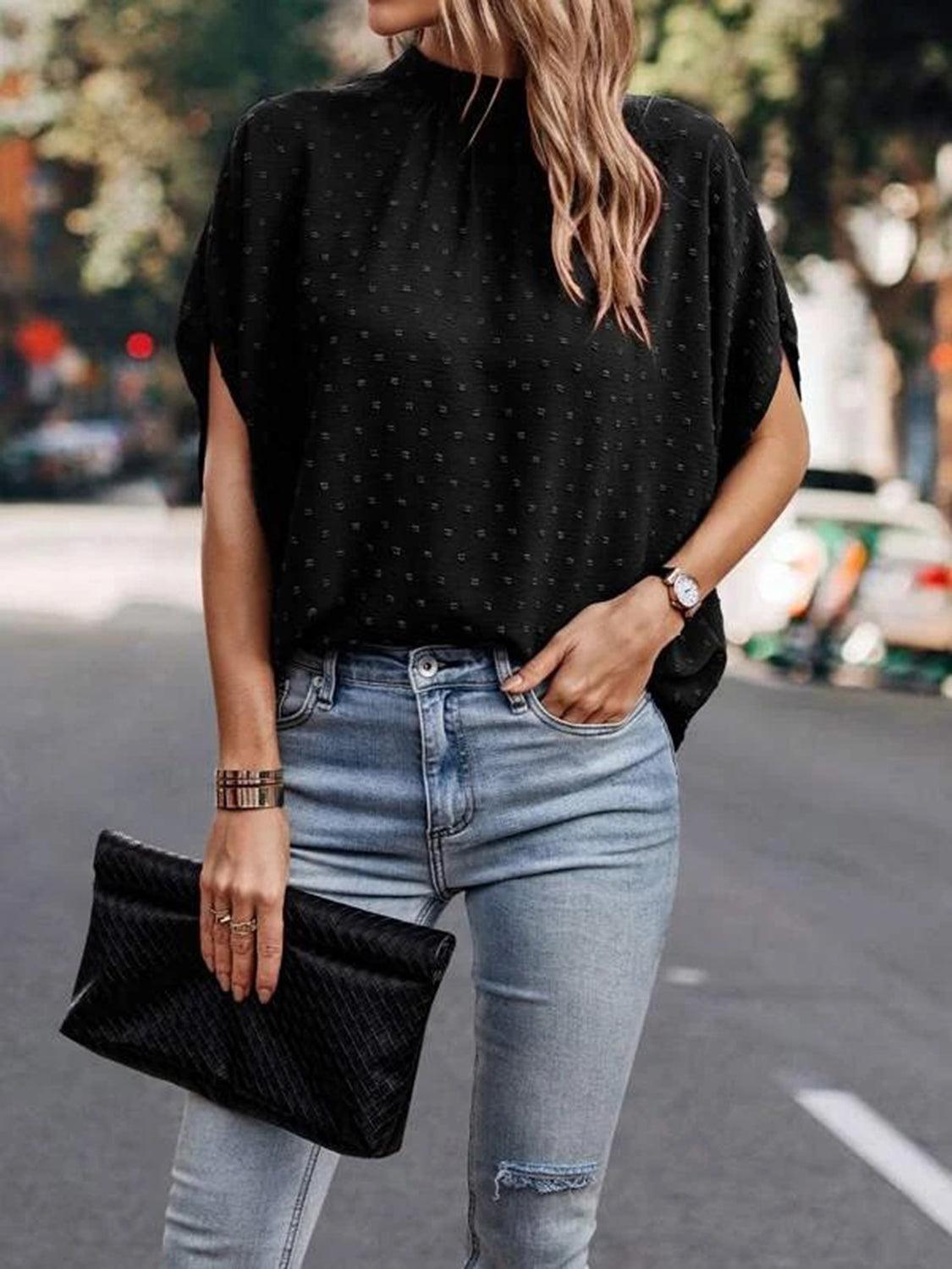 a woman wearing ripped jeans and a black top