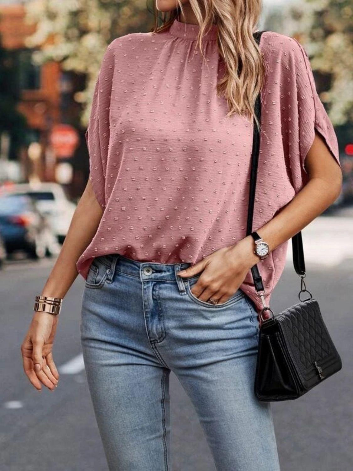 a woman wearing a pink top and jeans