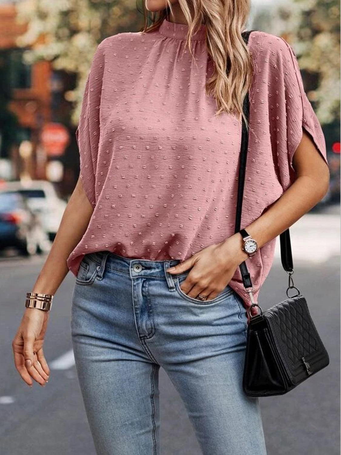 a woman wearing a pink top and jeans