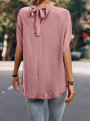 a woman wearing a pink blouse and jeans