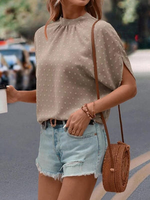 a woman is walking down the street holding a coffee cup