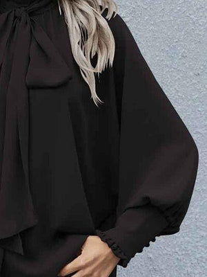 a woman wearing a black blouse and jeans