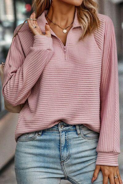 a woman wearing a pink sweater and jeans
