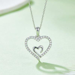 a heart shaped diamond pendant on a chain
