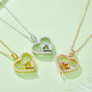 three heart shaped pendants on a green surface