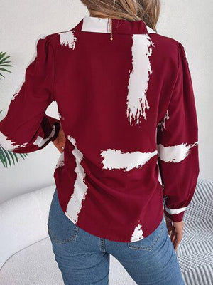 a woman wearing a red shirt with white paint on it
