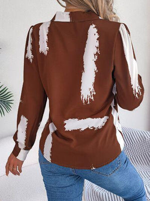 a woman wearing a brown shirt with white paint on it
