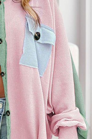 a woman wearing a pink and green sweater and jeans