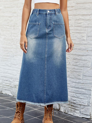 a woman in a white top and a denim skirt