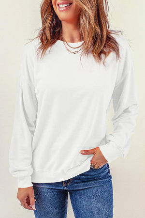 a woman wearing a white sweatshirt and jeans