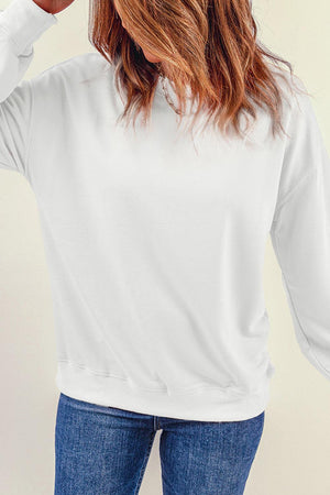 a woman wearing a white sweatshirt and jeans