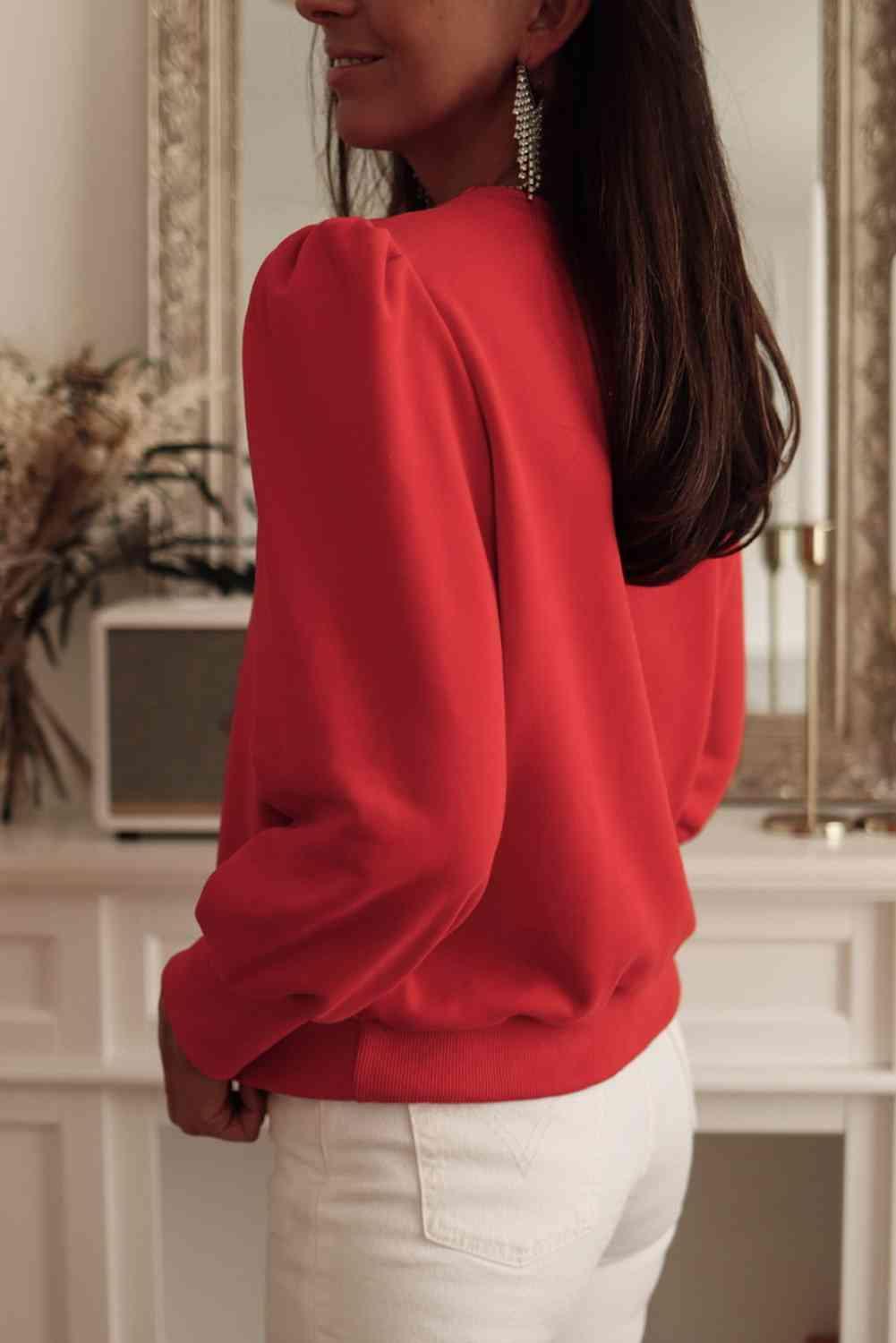 a woman wearing a red top and white pants