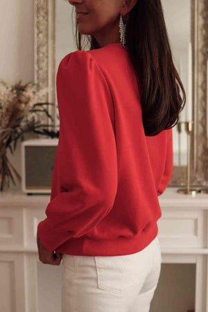 a woman wearing a red top and white pants