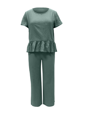 a woman wearing a green top and pants