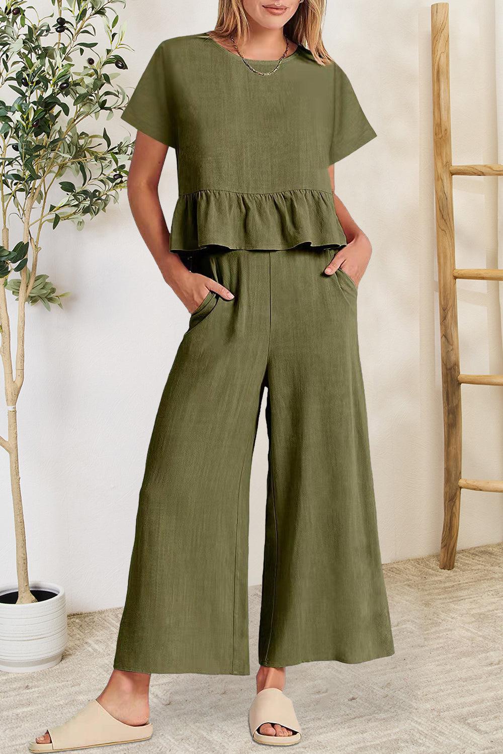 a woman wearing a green top and wide legged pants