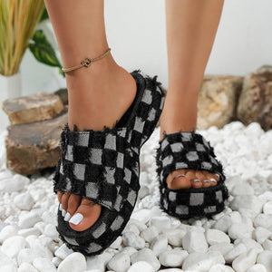 a close up of a person wearing black and white checkered sandals