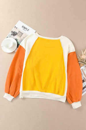 a yellow and white sweater sitting on top of a table