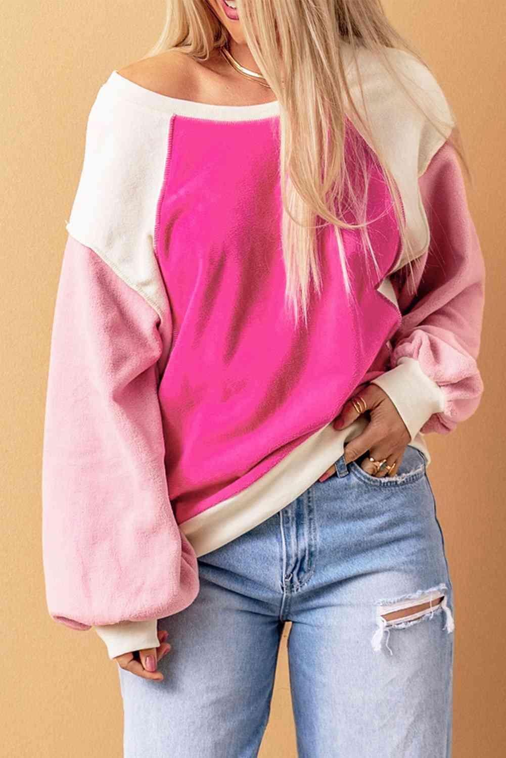 a woman wearing a pink and white sweater and ripped jeans