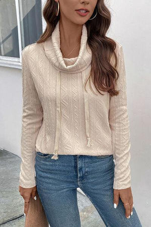 a woman wearing a white sweater and jeans