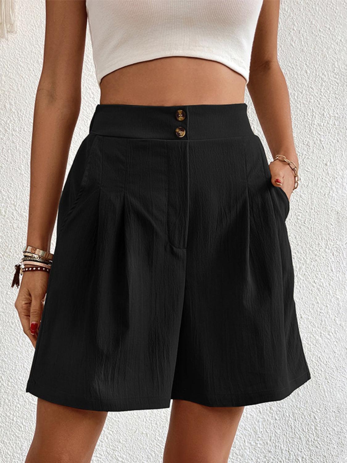 a woman wearing a white top and black shorts
