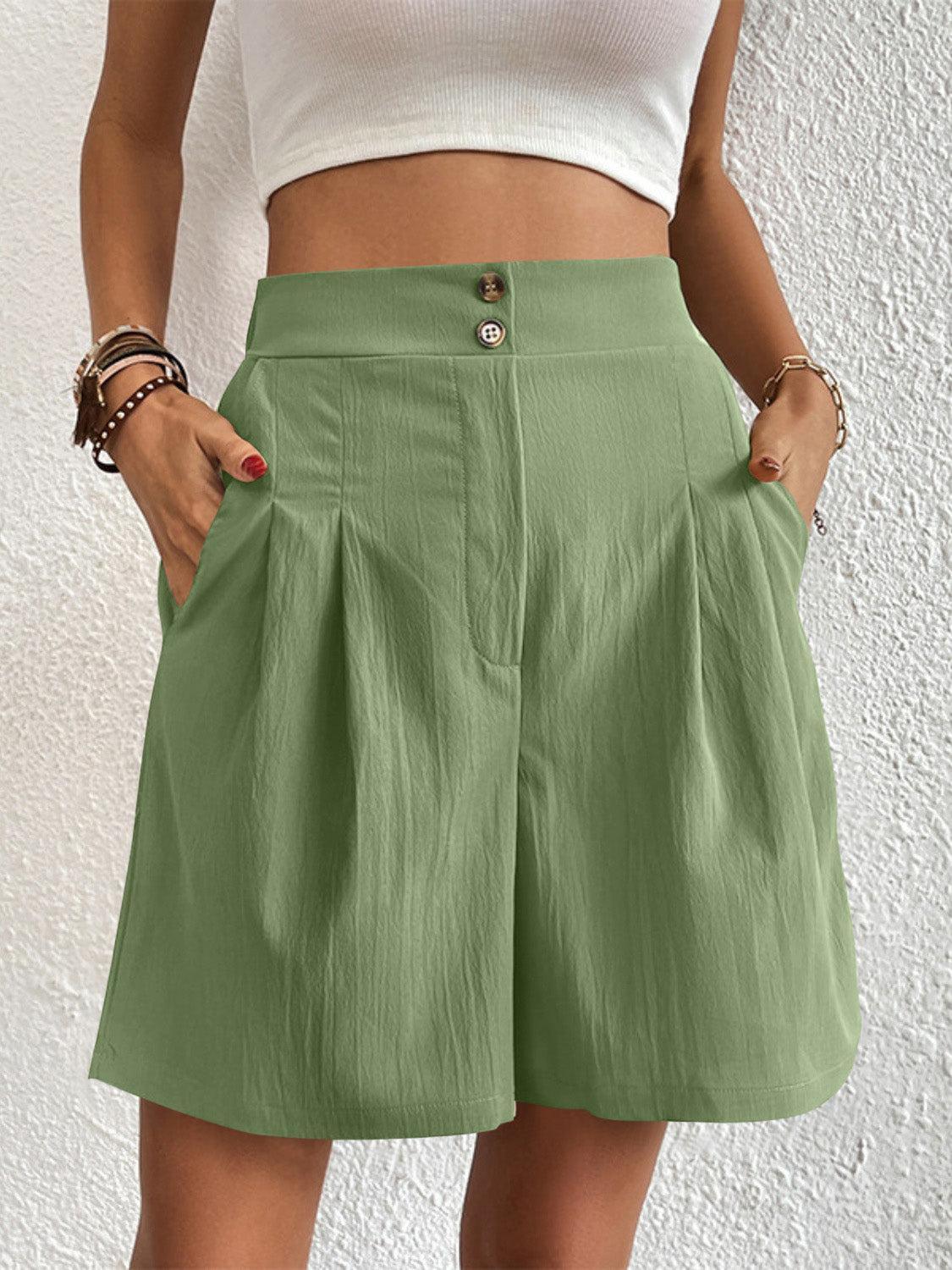 a woman wearing a white top and green shorts