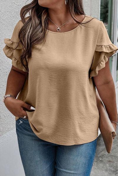 a woman wearing a tan top and jeans